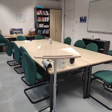 Image of the SunTrec Room showing a table surrounded by chairs, a white board and bookshelf